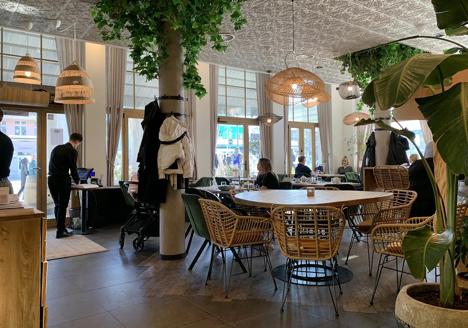 Salon Marisco z zielonymi fotelami i wiklinowymi abażurami